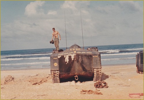 Cpl Joe McNeil standing on an Amtrac on the beach